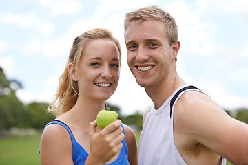 Image showing Couple, sport and portrait with apple, fitness and exercise on a field with a smile and wellness. Happy, healthy and athlete outdoor with fruit, nutrition and health together for workout and training