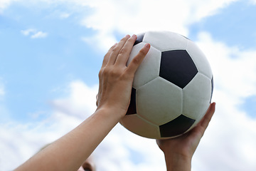 Image showing Hands, blue sky and closeup of ball for soccer exercise, game or training in outdoor field. Sports, fitness and zoom of person holding equipment for football match or workout in park or pitch.