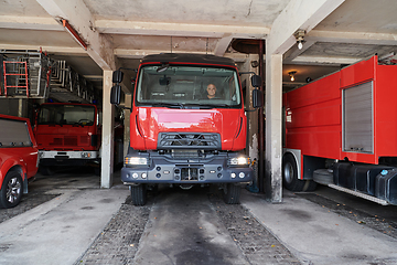 Image showing A dedicated firefighter preparing a modern firetruck for deployment to hazardous fire-stricken areas, demonstrating readiness and commitment to emergency response