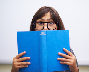 Image showing Student, child and hide face with book to read in front for classroom, shy and learning. Elementary school, girl kid and prepared oral with workbook, childhood development and academic education