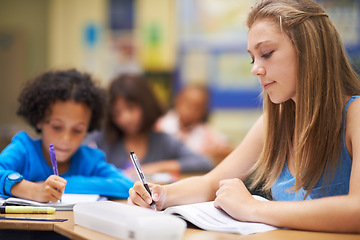 Image showing Girl, classroom and writing in book for education, learning and notes for knowledge in high school. Female person, notebook and pride for assessment or test, studying lesson and exam at academy