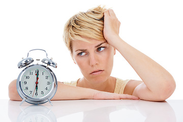 Image showing Sad woman, alarm clock and headache from alert, wakeup or deadline on a white studio background. Frustrated female person or blonde looking at time in failure, loss or bored on table on mockup space