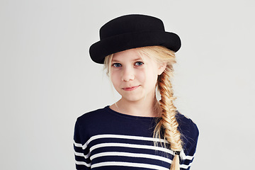 Image showing Fashion, happy and portrait of child in a studio with casual, cool and stylish outfit and hat. Smile, youth and young girl kid with positive, good and confident attitude for style by white background