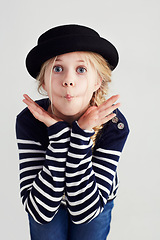 Image showing Fashion, goofy and girl child in a studio with casual, cool and stylish jersey outfit and hat. Silly, comic and funny young kid model with trendy youth style and positive attitude by gray background.