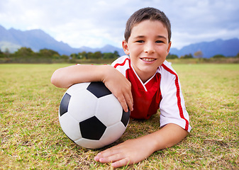 Image showing Boy, soccer player and ball with portrait, happy and ready for game, field and child. Outdoor, playful and sport for childhood, uniform and athlete for match, alone and outside on football pitch