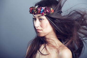 Image showing Woman, flower crown and wind in hair for beauty, skin glow and wellness on grey background. Keratin treatment, hairstyle with floral headband or accessory, dermatology and cosmetics in studio