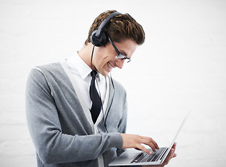 Image showing Happy man, laptop and headphones listening to music, audio or streaming on a gray studio background. Male person, nerd or geek smile with computer and headset for sound or podcast on mockup space