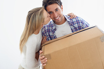 Image showing Couple, boxes and happy with kiss for real estate, new home or property investment with romance or love. Moving, man and woman with smile, hug or embrace for fresh start, achievement and dream house