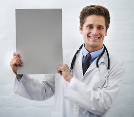 Image showing Happy man, portrait and doctor with poster in healthcare, advertising or marketing on a white studio background. Male person, nurse or medical surgeon smile with banner, blank sign or mockup space