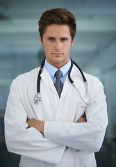 Image showing Serious, crossed arms and portrait of man doctor with stethoscope for confident attitude. Career, pride and professional young male healthcare worker in medical office of hospital or clinic.
