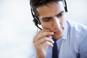 Image showing Call center, man and communication in studio of customer service, CRM questions and help on white background. Face, serious telemarketing agent and thinking of telecom advisory, microphone and mockup