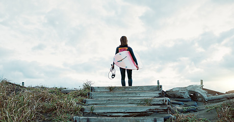 Image showing Surfing, beach and woman on stairs with surfboard for water sports, fitness and freedom by ocean. Nature, travel and back of person for wellness on holiday, vacation and adventure by tropical sea