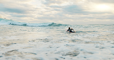 Image showing Surfing, ocean and woman with waves on surfboard for water sports, fitness or freedom by beach. Nature, travel and person on holiday, tropical vacation and adventure by sea for hobby, fun or activity