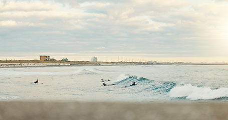 Image showing Sea, sports and people surfing at beach on blue sky for fitness, health or recreation in summer. Exercise, nature and water with surfer group in ocean for travel, holiday or vacation on coast space