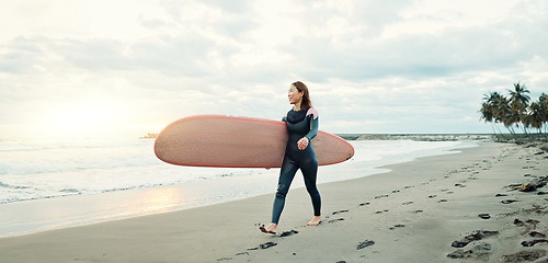 Image showing Woman, surfing board and walking on sand at beach, sea and ocean for summer holiday, travel adventure and happiness. Japanese surfer on shore for water sports, freedom and relax for tropical vacation