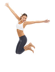 Image showing Woman, jumping and fitness in studio for exercise or wellness health or performance, mockup or white background. Female person, excited and leap or gym workout pride for balance, yoga or flexibility