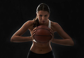 Image showing Serious, woman and portrait with basketball for sports and game in black background or studio. Fitness, challenge and intense athlete on the court, competition or training in workout and exercise