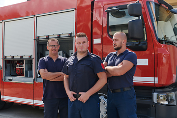 Image showing A skilled and dedicated professional firefighting team proudly poses in front of their state of the art firetruck, showcasing their modern equipment and commitment to ensuring public safety.