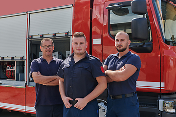 Image showing A skilled and dedicated professional firefighting team proudly poses in front of their state of the art firetruck, showcasing their modern equipment and commitment to ensuring public safety.