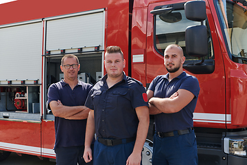 Image showing A skilled and dedicated professional firefighting team proudly poses in front of their state of the art firetruck, showcasing their modern equipment and commitment to ensuring public safety.