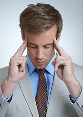 Image showing Businessman, headache and burnout in studio for job, mental health and bankrupt or stress. Male person, migraine and frustrated by white background, deadline and depression or mistake and tension