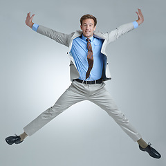 Image showing Businessman, celebration and jumping for triumph in portrait, studio and corporate winner. Male person, professional and victory or accomplishment, cheering and energy or bonus by gray background