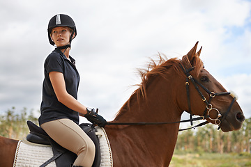 Image showing Equestrian, riding and woman on horse in nature on adventure and journey in countryside. Ranch, animal and rider outdoor with hobby, sport or pet on farm trail with girl in summer on blue sky