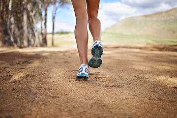 Image showing Legs, sneakers and person running in nature, woods or forest with fitness for health and wellness outdoor. Sports, workout and training, behind runner in race or marathon athlete for exercise in park