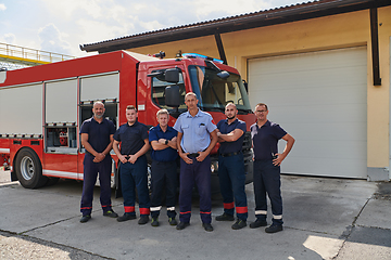 Image showing A skilled and dedicated professional firefighting team proudly poses in front of their state of the art firetruck, showcasing their modern equipment and commitment to ensuring public safety.