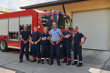 Image showing A skilled and dedicated professional firefighting team proudly poses in front of their state of the art firetruck, showcasing their modern equipment and commitment to ensuring public safety.