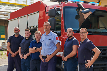 Image showing A skilled and dedicated professional firefighting team proudly poses in front of their state of the art firetruck, showcasing their modern equipment and commitment to ensuring public safety.