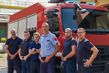 Image showing A skilled and dedicated professional firefighting team proudly poses in front of their state of the art firetruck, showcasing their modern equipment and commitment to ensuring public safety.