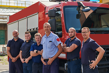 Image showing A skilled and dedicated professional firefighting team proudly poses in front of their state of the art firetruck, showcasing their modern equipment and commitment to ensuring public safety.