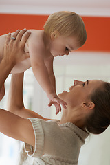 Image showing Baby, mother and playing in home for wellness with nurture, relationship and bonding for happiness. Family, child or toddler and embrace with early childhood, parenting and smile in living room