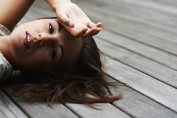 Image showing Woman, portrait and confident on porch for relax outdoor in backyard and break, lying down and rest in home. Person, face or calm on wooden deck in garden of house or apartment and carefree or casual