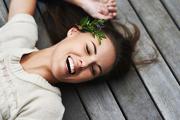 Image showing Woman, face and happy on porch for relax outdoor in backyard with flower, lying down and rest in home. Person, spring and smile on wooden deck in garden of house or apartment with carefree or casual