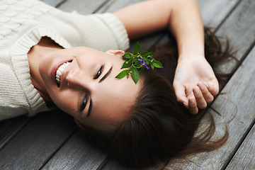 Image showing Woman lying on her porch, relax and summer with smile, happiness and chilling on a weekend break. Person, outdoor and girl with joy, cheerful and plant in her hair, holiday and floral with vacation