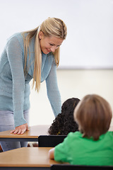 Image showing Teacher, children and students in classroom for education, learning and language development or support at desk. Happy woman with kids for teaching, helping with knowledge and questions at school