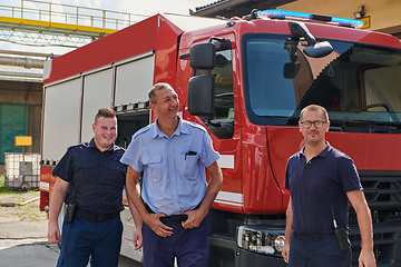 Image showing A skilled and dedicated professional firefighting team proudly poses in front of their state of the art firetruck, showcasing their modern equipment and commitment to ensuring public safety.