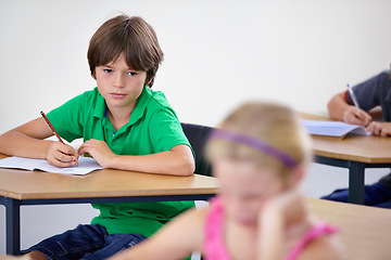 Image showing Children, education and boy writing a test, knowledge and learning with an exam, information and school. Kids, classroom and child development with a notebook, studying and desk with girl or creative