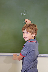 Image showing Portrait, chalk and boy drawing on a board for child development, confidence and art for learning. Academic, creative and kid student writing on a blackboard in the classroom with face and happy