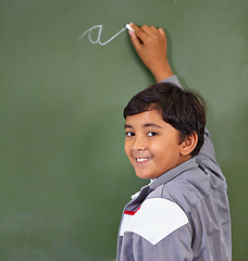 Image showing Portrait, chalk and boy writing on a board for child development, confidence and art for learning. Academic, creative and kid student drawing on a blackboard in the classroom with face and excited