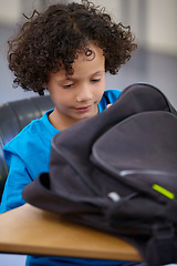 Image showing Boy, education and school bag with thinking, child development and searching with learning, study and table. Kid, classroom or student with a backpack, desk and confident with information and excited