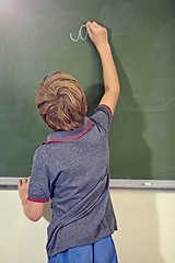 Image showing Kid, chalkboard and school with writing education, lecture and answer for learning. Back, knowledge and youth development in a study lesson with male student in classroom with chalk and solution