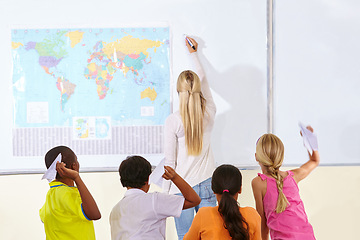 Image showing Teacher, woman and children in a classroom, playing and knowledge with information, paper planes and learning. School, group and educator writing on a board, studying and geography with students