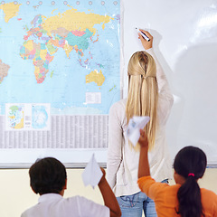 Image showing Teacher, woman and children in a classroom, learning and knowledge with information, paper planes and studying. Students, group and educator writing on a board, education and world map with school