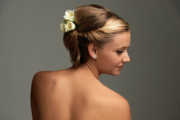 Image showing Shine, skincare and woman with cosmetics, beauty or luxury on a grey studio background. Person, girl or model with aesthetic, hairstyle or grooming with flowers, healthy skin or dermatology with updo