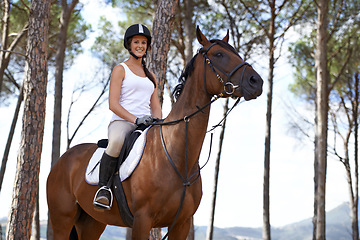 Image showing Portrait, horse riding or happy woman in woods or forest with rider or jockey for recreation or adventure. Smile, relax or equestrian with a pet animal for training, exercise or wellness in nature