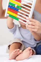 Image showing Abacus, math and baby with mother playing, learning and teaching for child development on bed. Bonding, toy and closeup of mom with kid, infant or toddler with counting together in bedroom at home.