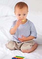 Image showing Cute, bed and baby eating biscuit for yummy snack playing with abacus for education. Child development, sweet and hungry young boy kid, infant or toddler enjoying a cracker in bedroom at home.